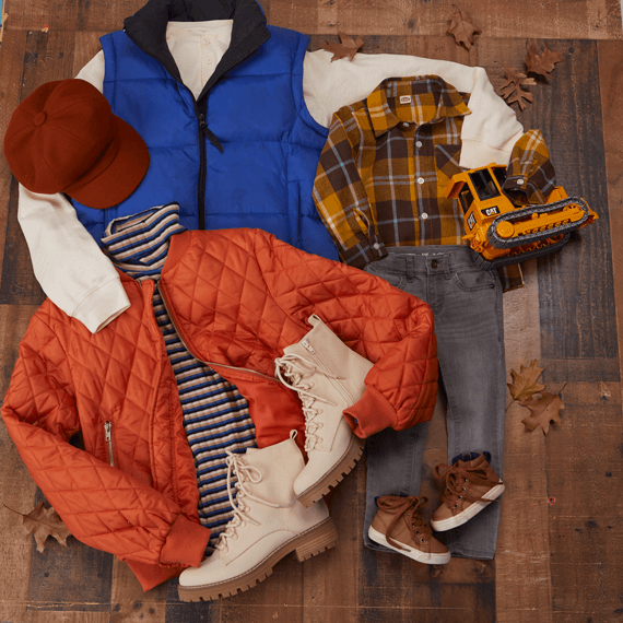 An orange jacket paired with a blue vest and brown boots. A mustard yellow plaid children's shirt and light washed black jeans.