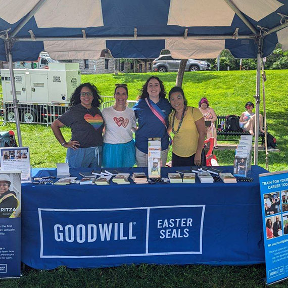 four women volunteer at Goodwill's booth at 2024 Twin Cities Pride Festival