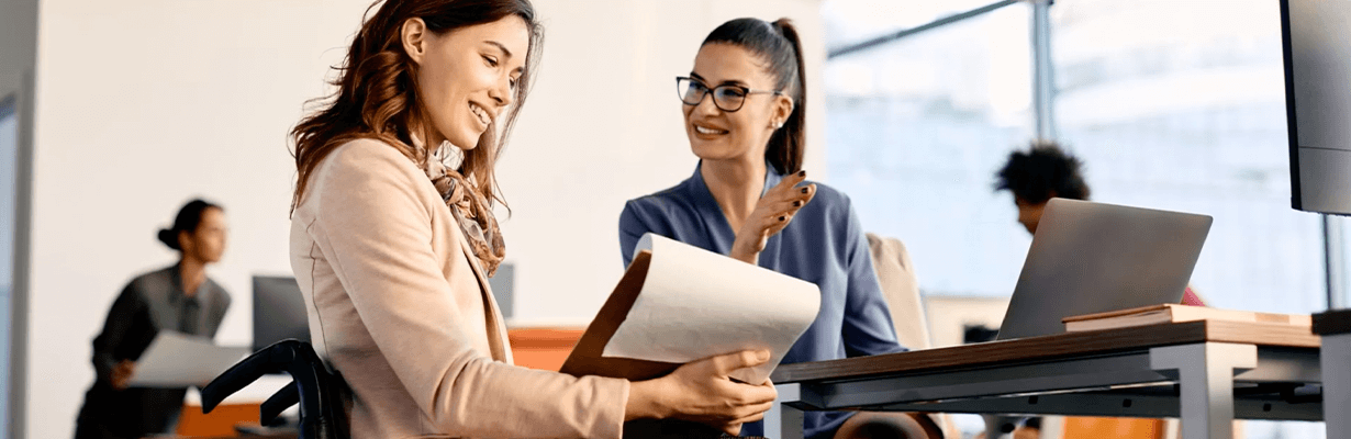 Two females sitting next to each other in front of a laptop