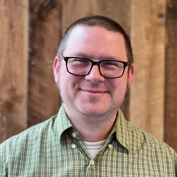 man-with-glasses-wearing-a-green-and-white-stripped-shirt