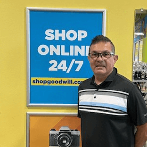 Felix smiling and standing by a shop online sign