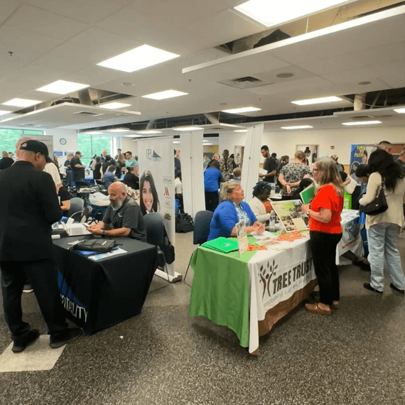 a crowd of people surround several tables at a career fair
