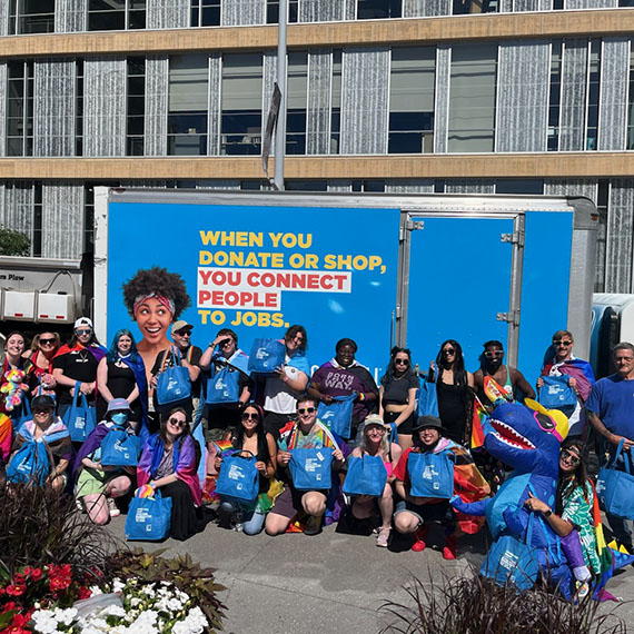 Dozens of people pose in front of Goodwill's truck at the Twin Cities 2024 Pride Parade